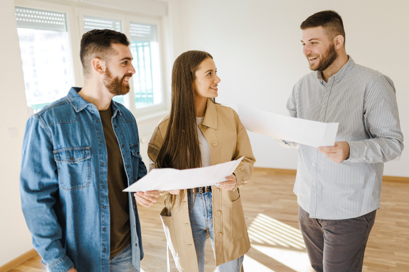 Real estate agent showing an apartment for sale to a young couple