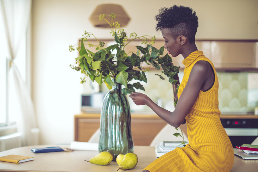 A woman fixing a plant placed on a vase
