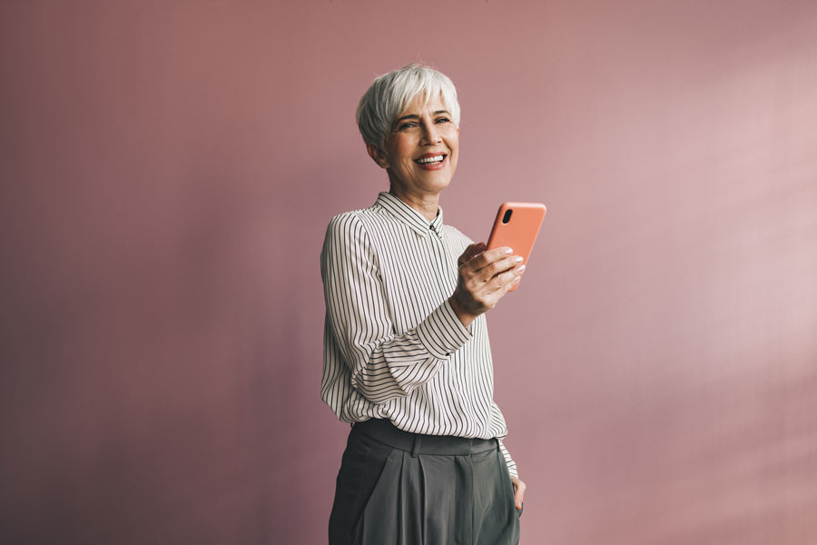 A woman holding a phone and smiling